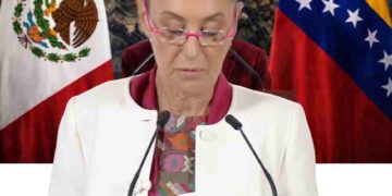 Claudia Sheinbaum habla sobre soberanía de México, con banderas de México y Venezuela al fondo