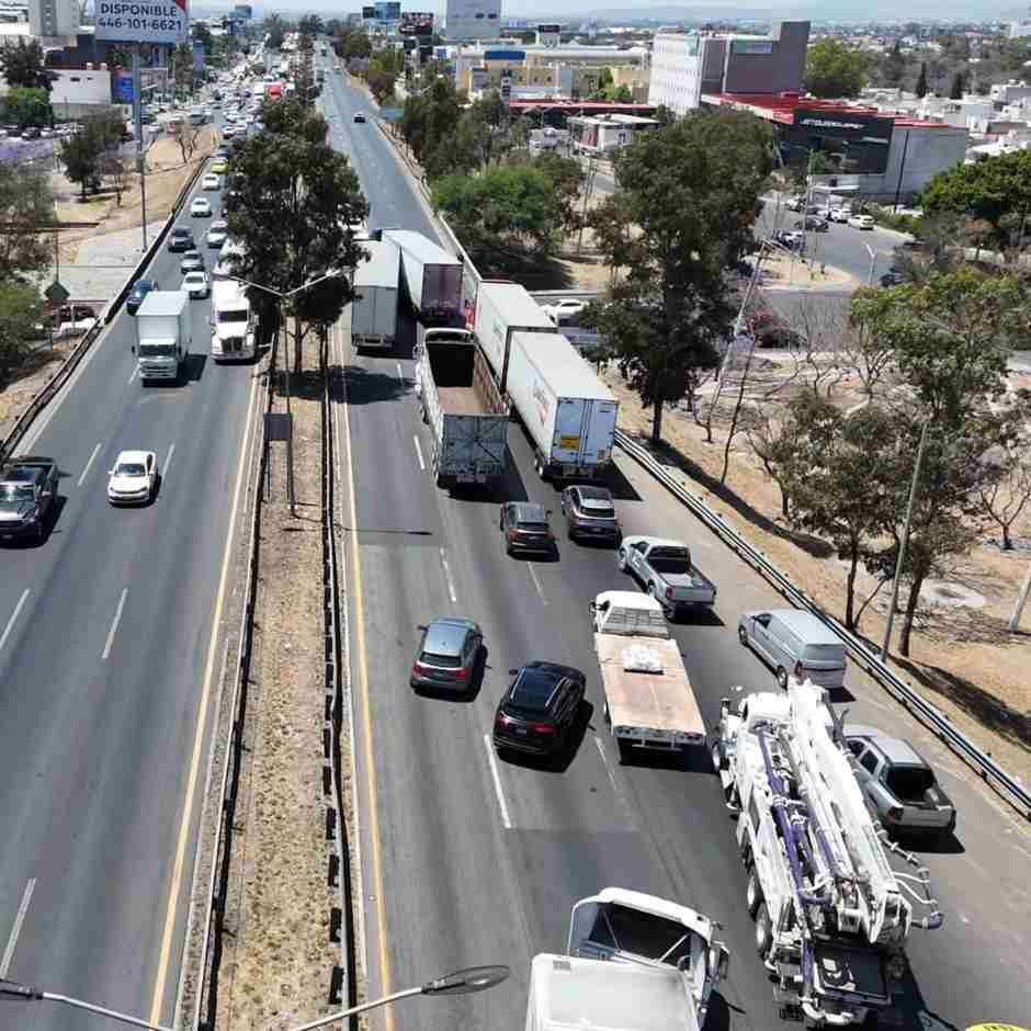 Vista aérea de tráfico intenso con tráileres y automóviles en una avenida principal de Querétaro